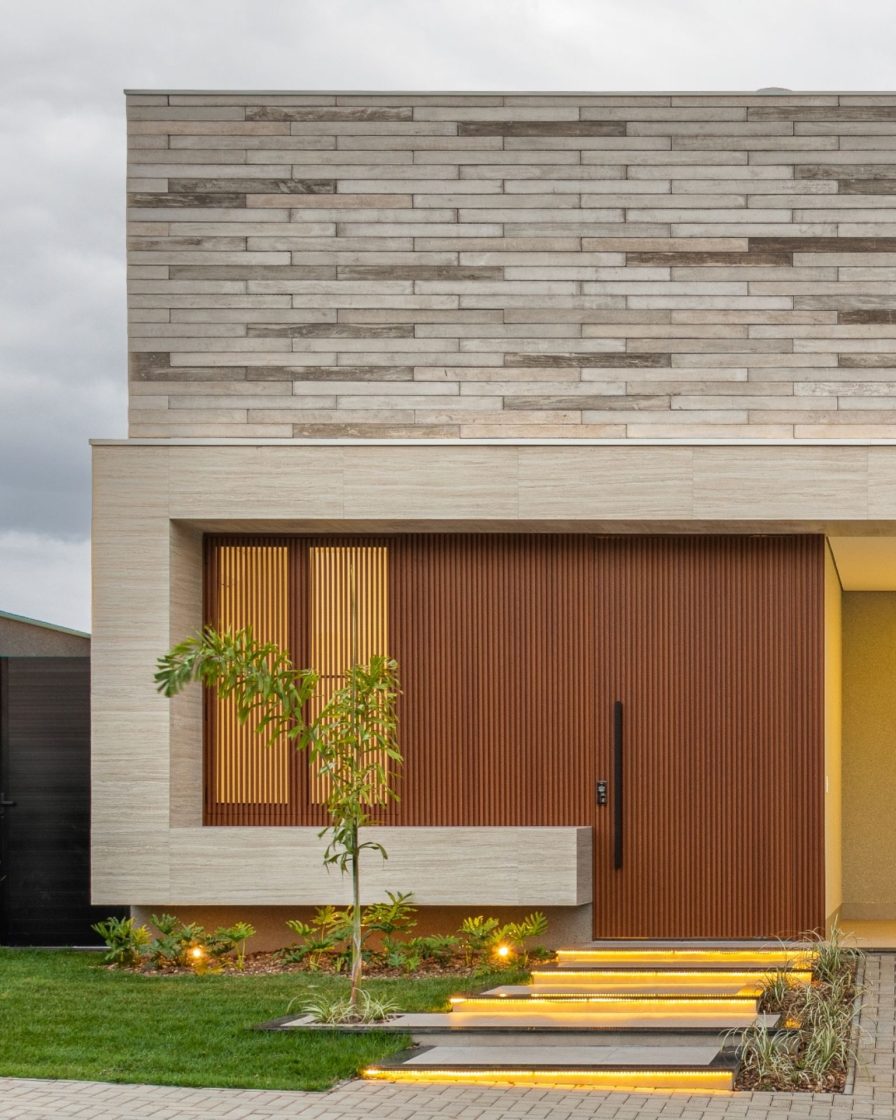 Entrada de casa com revestimento porcelanato e detalhes em madeira