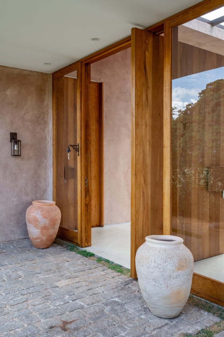 Entrada de casa rústica com vasos decorativos