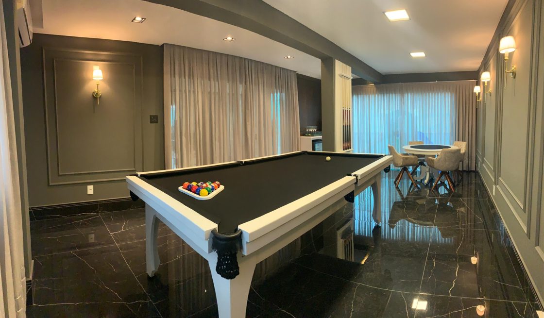 Sala de jogos com piso marmorizado preto e paredes verdes