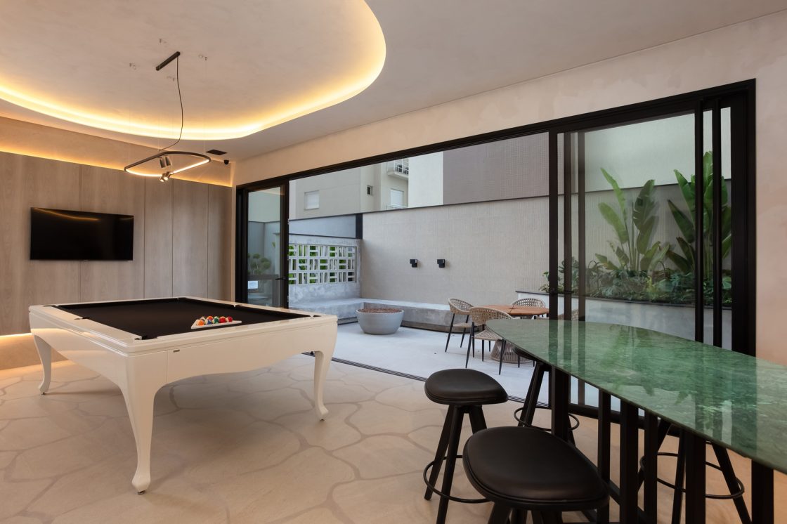 Sala de jogos integrada ao espaço externo com mesa de sinuca