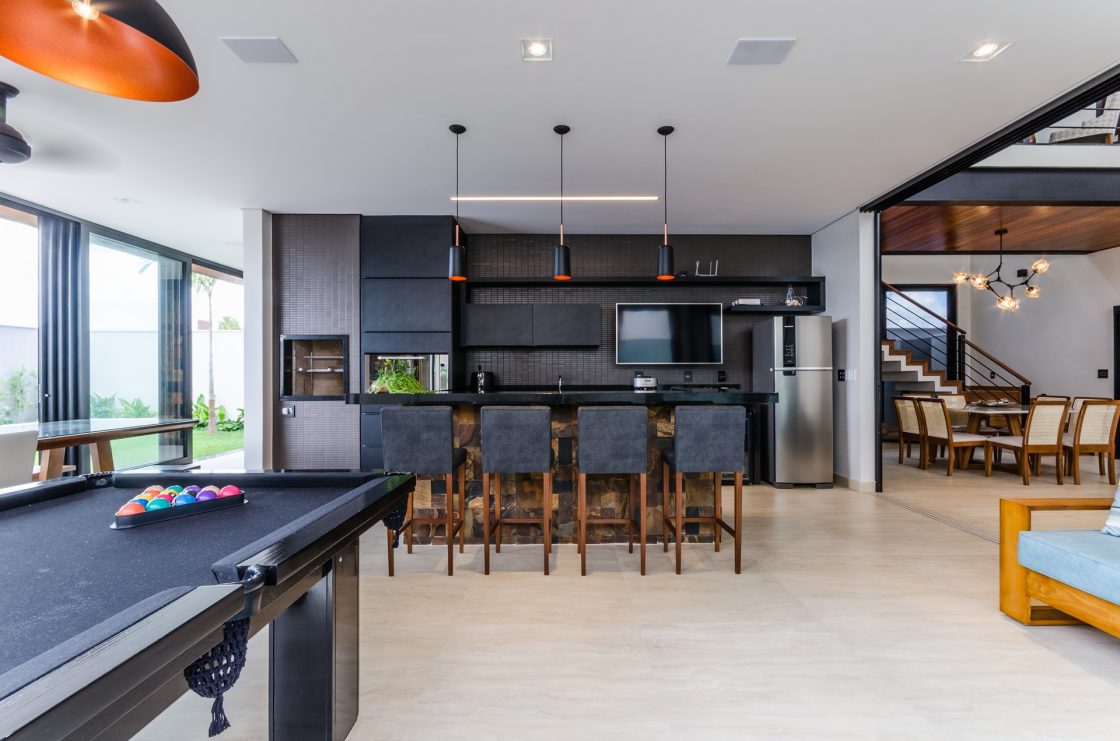 Sala de jogos ampla e integrada ao espaço gourmet e à sala