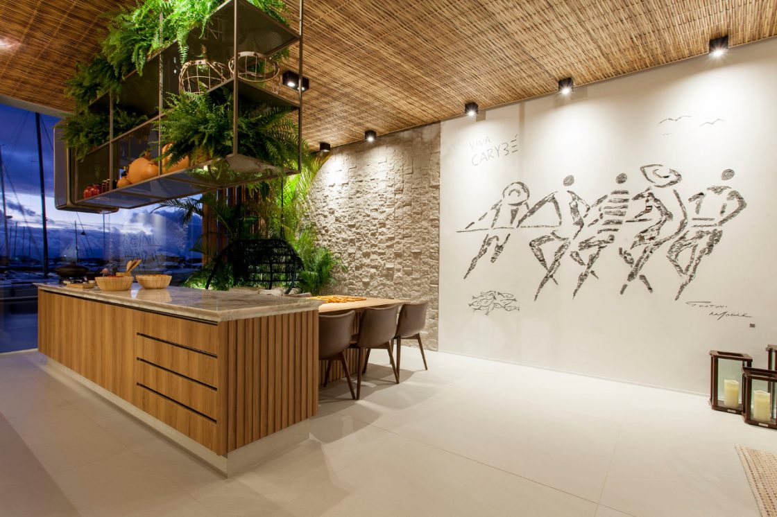 Cozinha aberta com ilha em madeira e nicho aéreo decorado com plantas