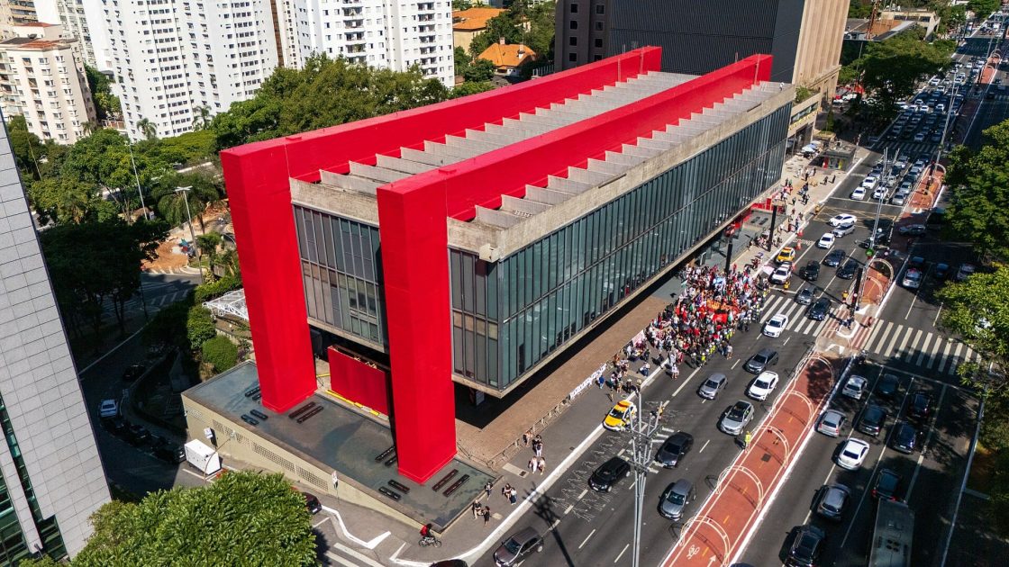 Vista aérea do MASP, na Avenida Paulista, em São Paulo, destacando sua estrutura suspensa apoiada em pilares vermelhos e o famoso vão livre