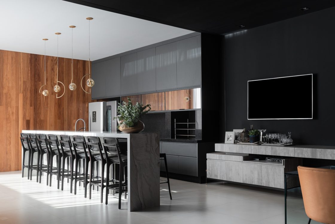 Varanda gourmet com luminárias pendentes sob bancada