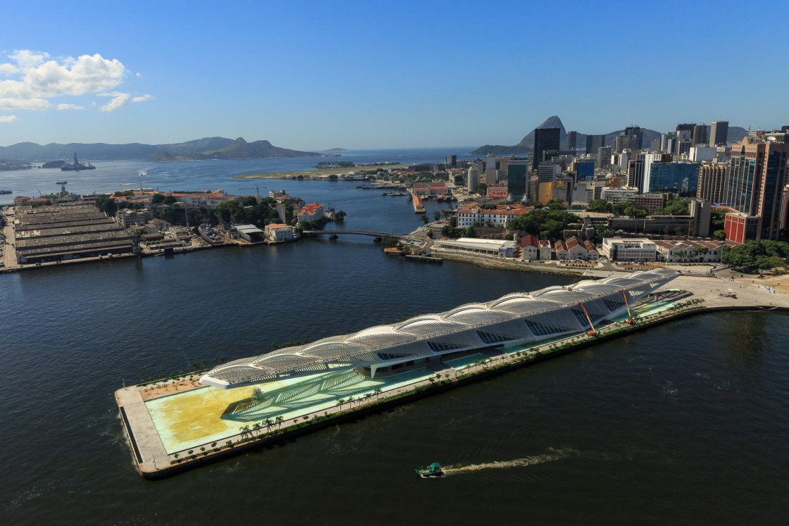 Vista aérea do Museu do Amanhã e do Píer Mauá, com Baía de Guanabara e Pão de Açúcar ao fundo