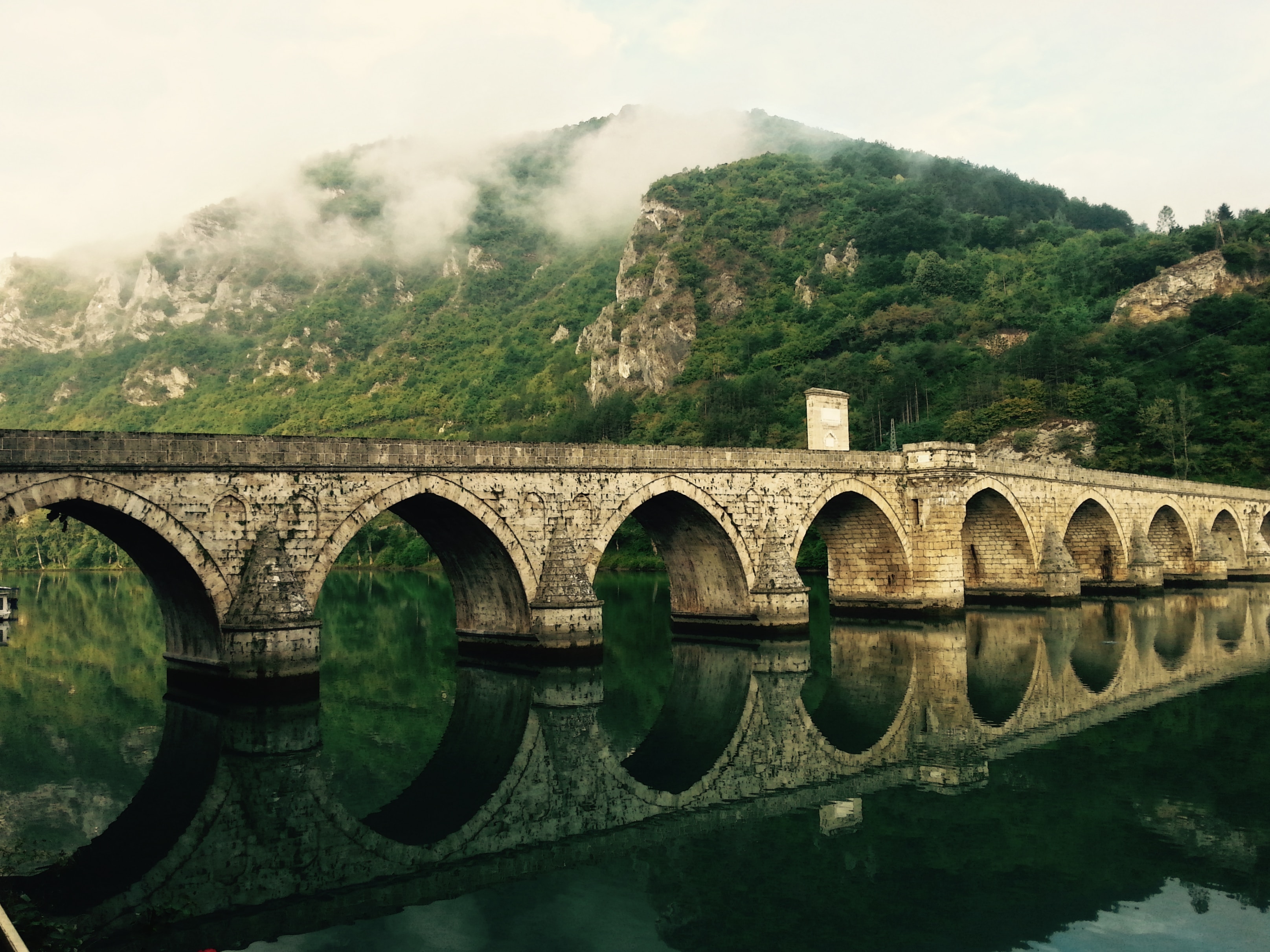 Na foto, ponte na cidade Višegrad na Bósnia e Herzegovina. Localizada no Rio Drina entre as cidades de Goražde, Ustiprača e Užice (Foto: Unsplash)