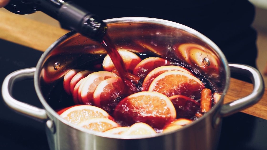 Panela com quentão preparado com vinho, rodelas de laranja e especiarias, bebida tradicional das festas juninas brasileiras