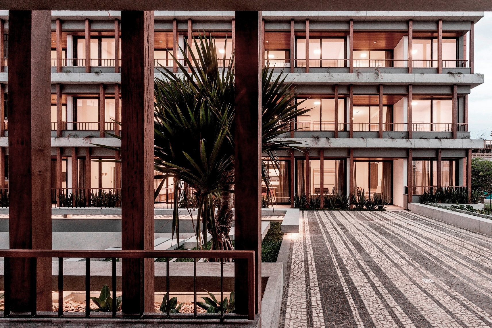 O projeto explora a expressão dos materiais: mistura floreiras e escadas em concreto aparente em contraposição a vegetação e a madeira que marcam a composição modular como elemento básico da edificação. Fotos Fernando Willadino.