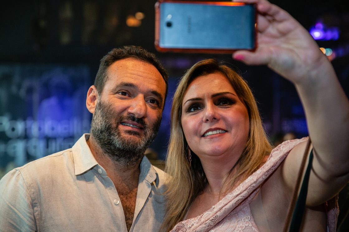Mulher fazendo selfie ao lado de Marcelo Rosenbaum