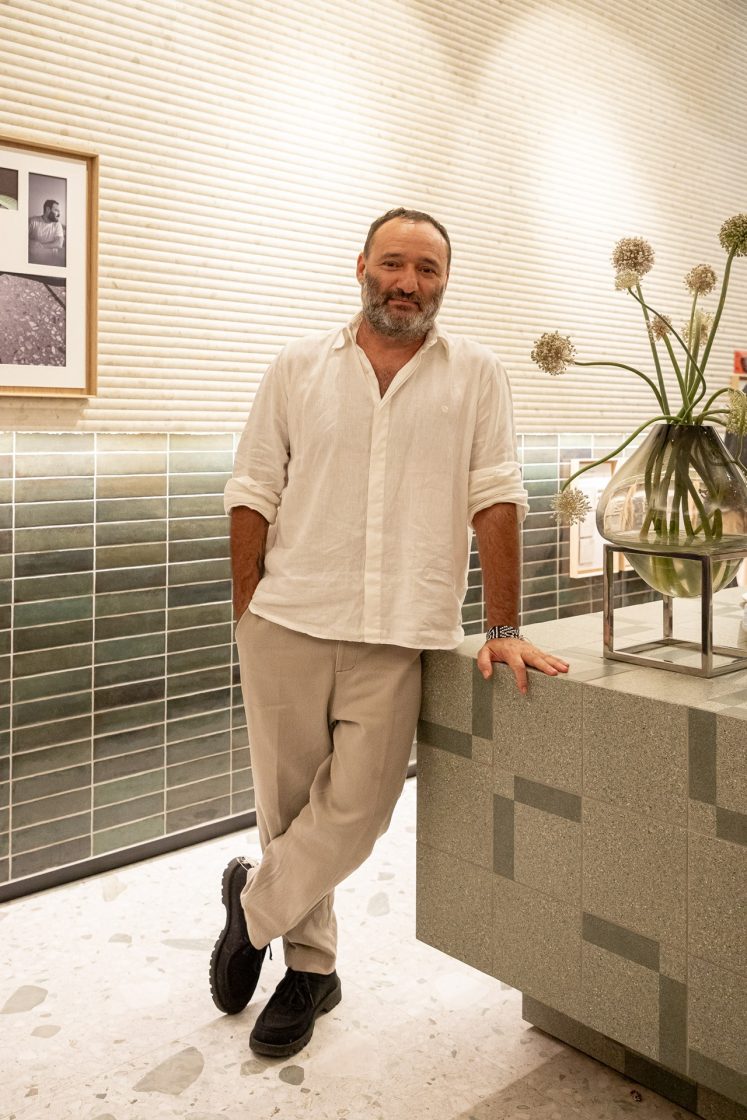 Marcelo Rosenbaum apoiado em bancada com revestimento Samba Rock