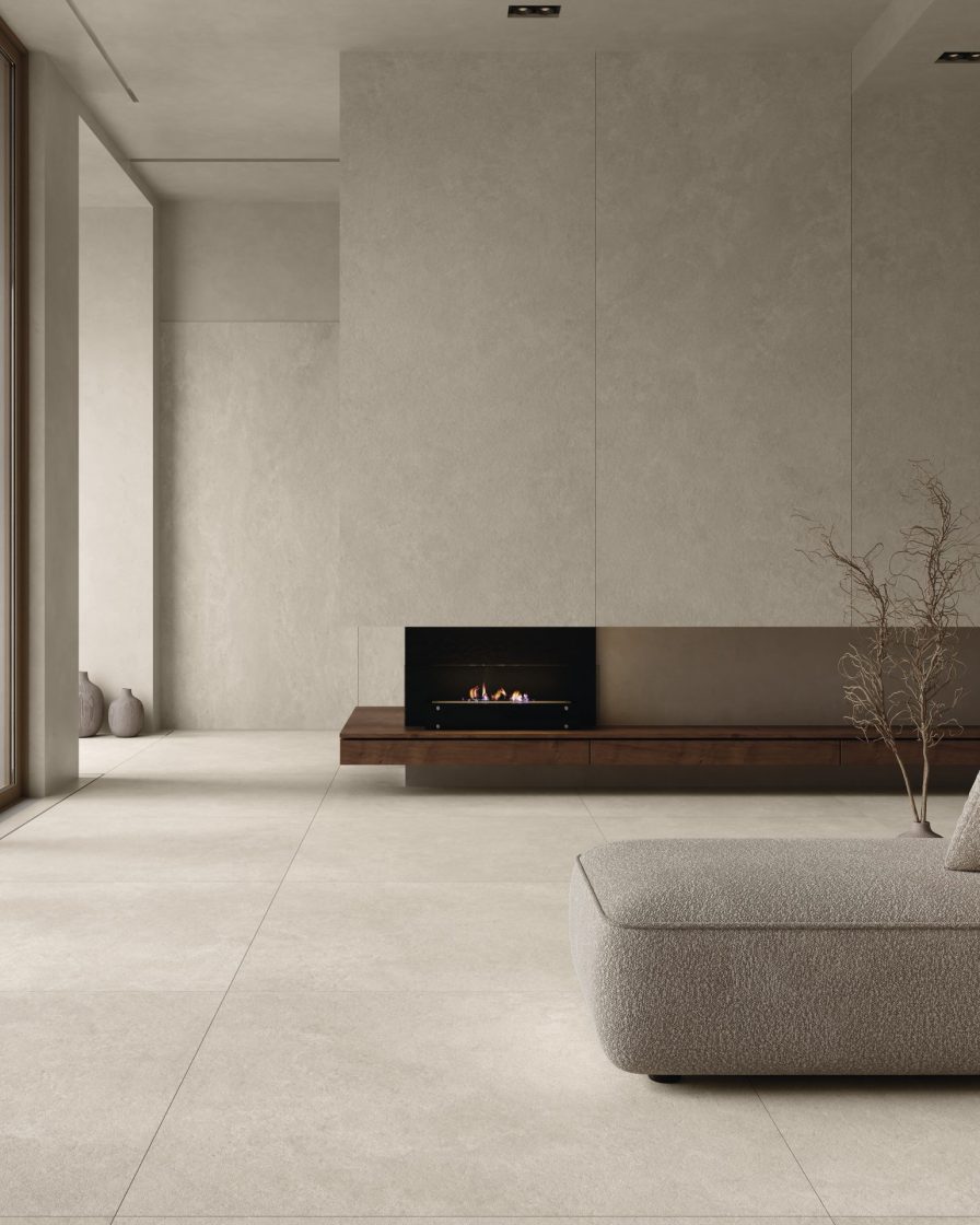 Living com revestimento que reproduz limestone no piso e nas paredes. Uma lareira aparece ao fundo