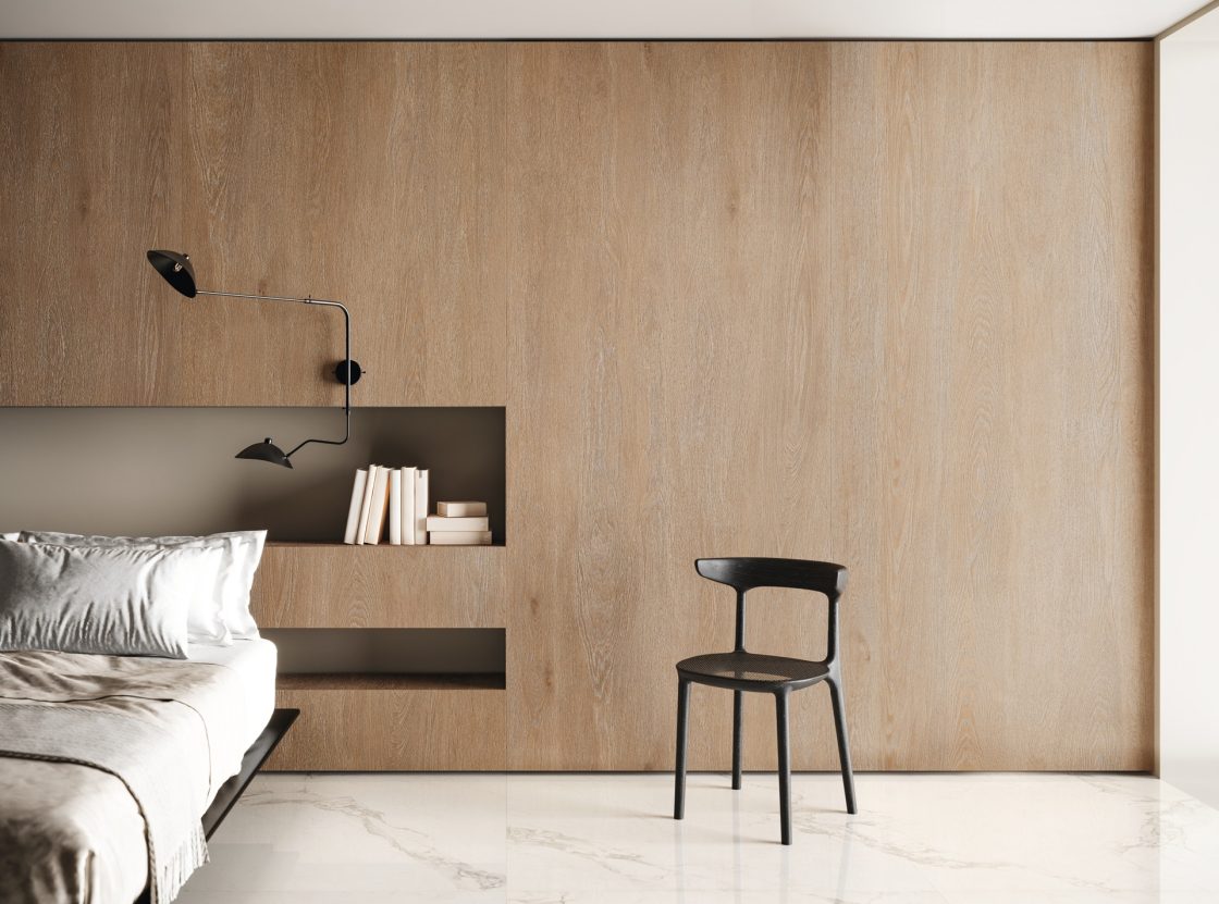Quarto de casal com cabeceira de porcelanato que reproduz madeira