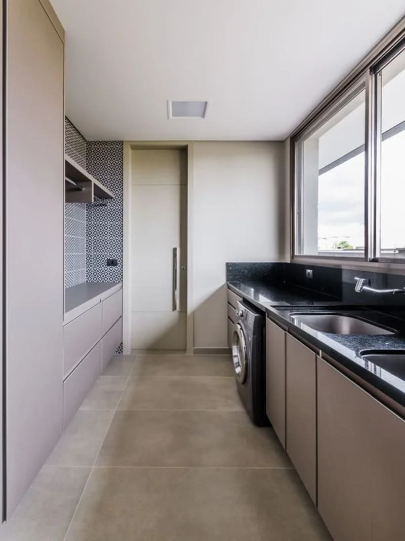 área de serviço com duas pias, um armário embutido claro e uma máquina de lavar, ambiente sem artigos de decoração com ar minimalista 
