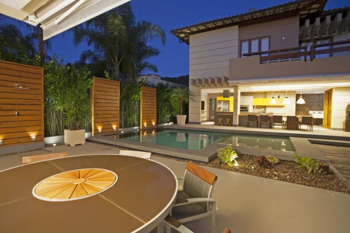 Área gourmet integrado com espaço de lazer com piscina e elementos naturais.