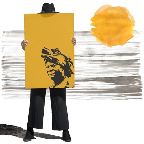 obra angolana de tons amarelos um homem segura uma figura