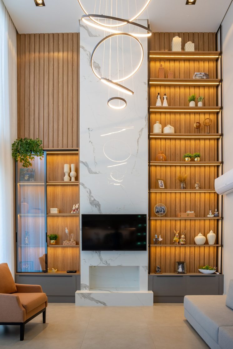 Sala com estante embutida e lareira clássica em porcelanato marmorizado branco