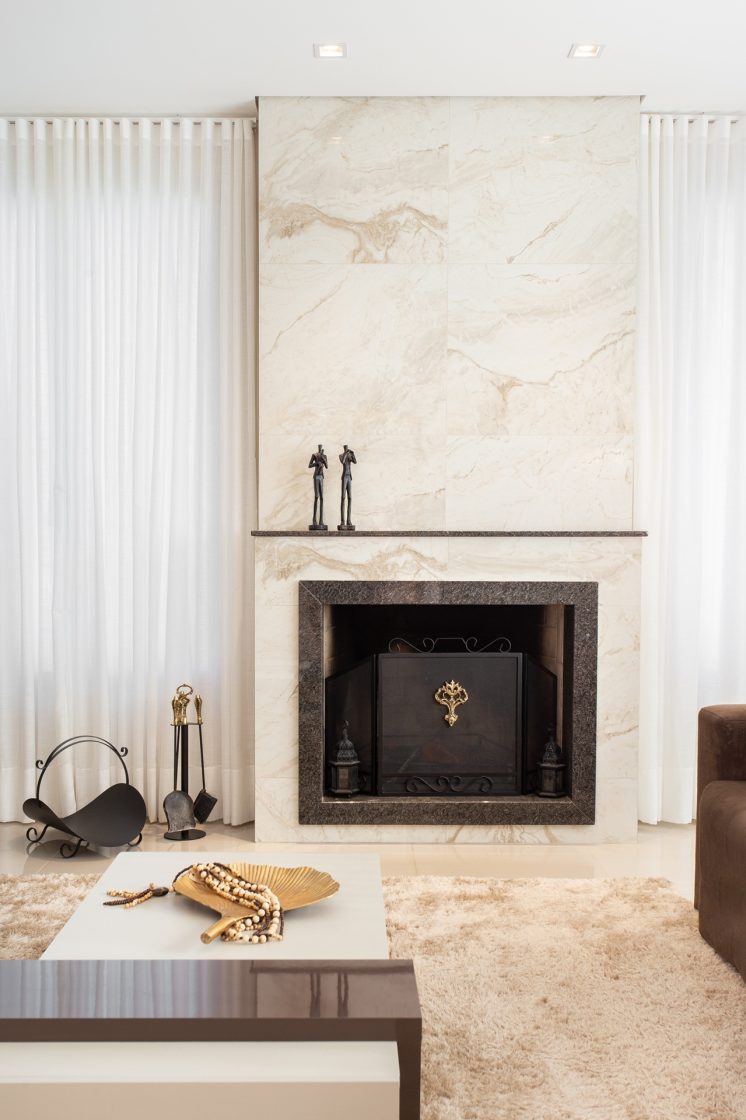 Sala com lareira embutida em painel de porcelanato marmorizado branco