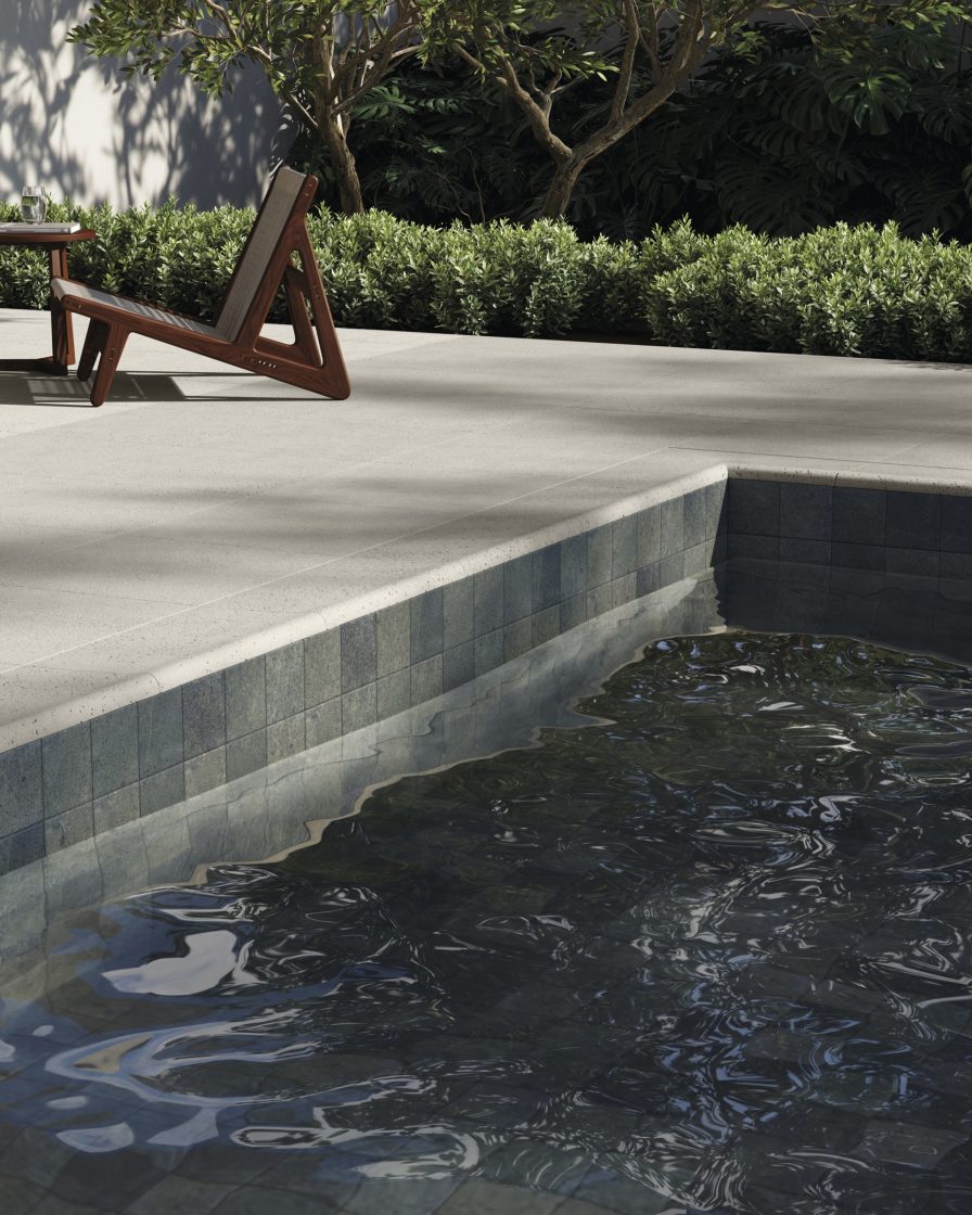 Borda piscina de alvenaria com revestimento que reproduz pedra no interior e cimentício no entorno