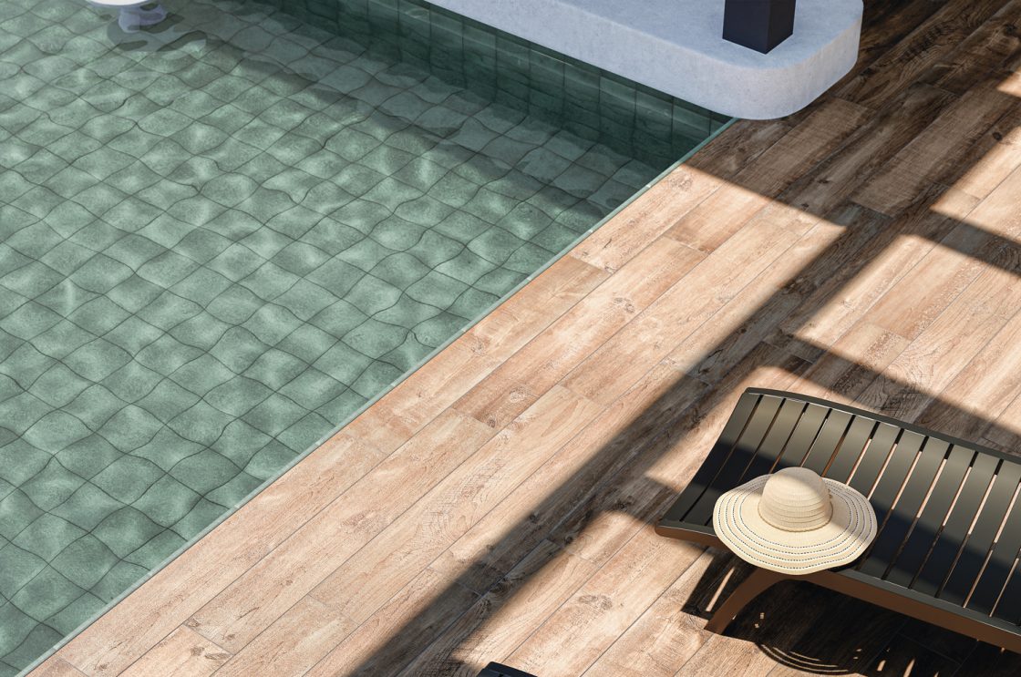 Close em piscina com revestimento cerâmico verde e entorno amadeirado
