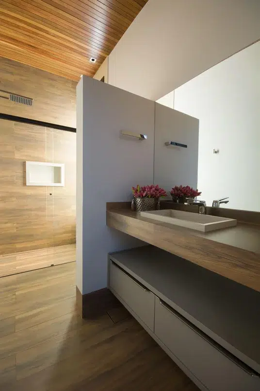 Banheiro com conceito aberto e acabamento em madeira