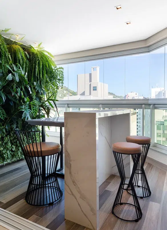 Área gourmet em apartamento com bancada ilha e plantas num jardim vertical