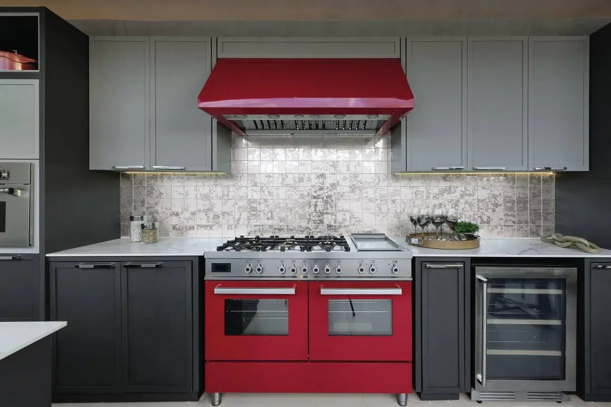 Cozinha com móveis vermelhos e armários cinza