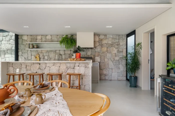 Cozinha com estilo natural com mesa de madeira, bancada ilha e decoração de plantas