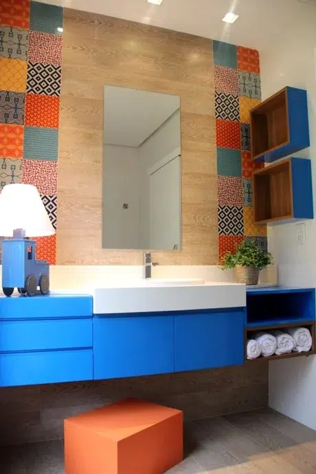 Bancada azul de banheiro com espelho e parede de azulejos