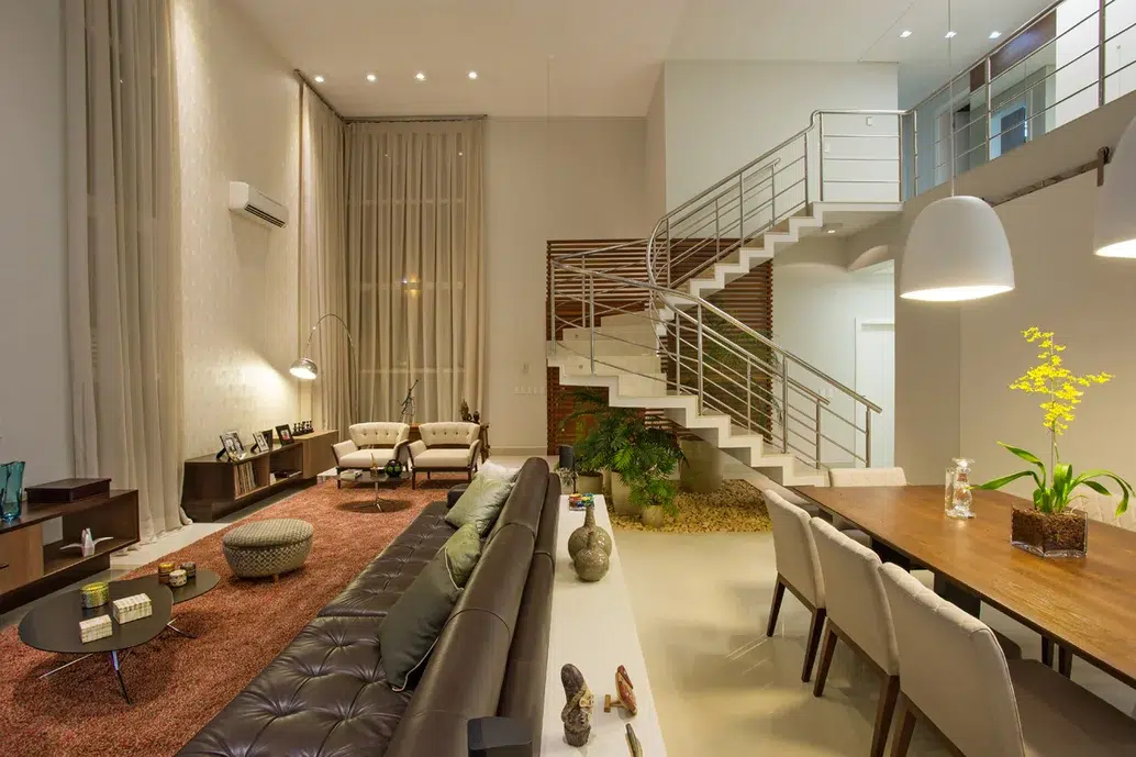 sala de jantar e sala de estar moderna integradas com pé direito duplo  e escada para segundo andar 
