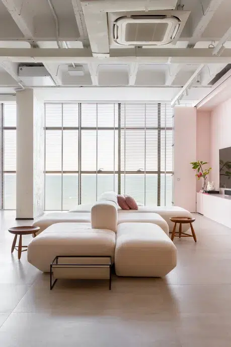 Lounge com sofá duplo e elementos em rosa