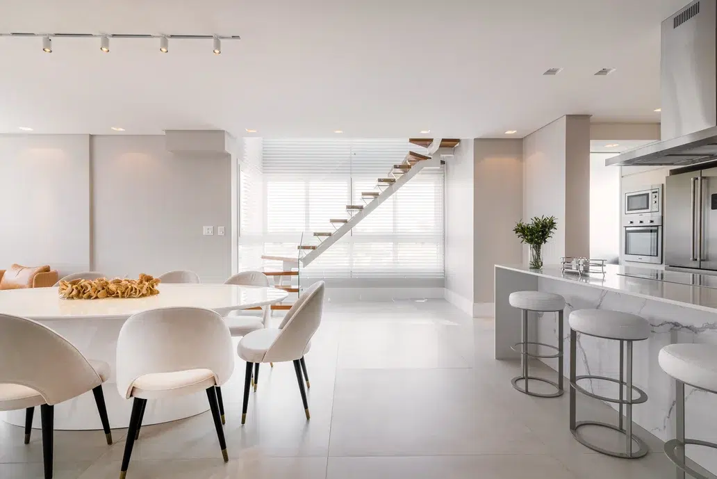 sala e escada de um departamento duplex estilo minimalista em cores brancos