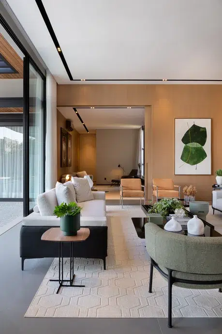 Sala de estar com elementos verdes, detalhes pretos e parede em tons amadeirados