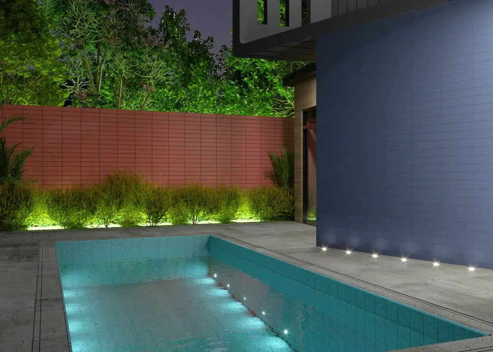 area externa de uma casa com um muro em cor azul petroléo, uma piscina e decoração de luzes.