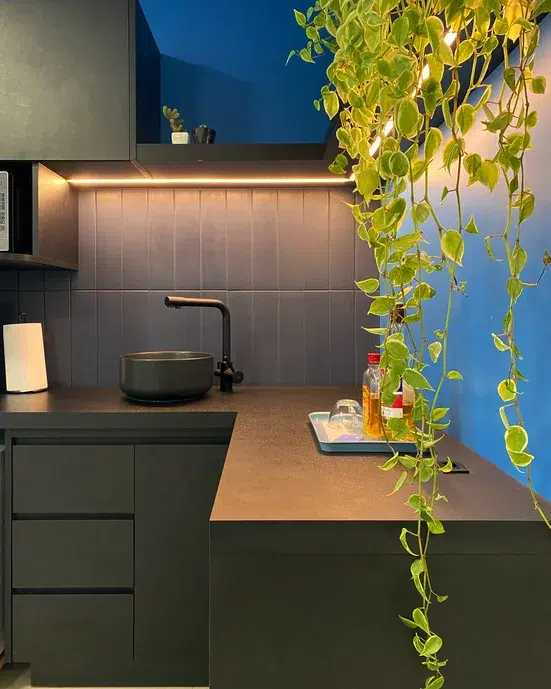 Cozinha em tom azul petróleo com decoração minimalista.