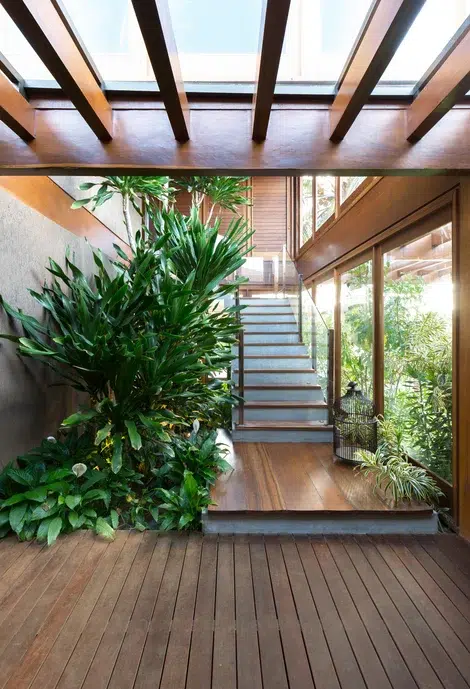 espaço externo de uma casa projetado como interno com plantas do lado da escada