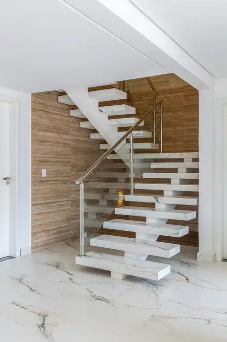 Escada de porcelanato com varanda de  vidro.