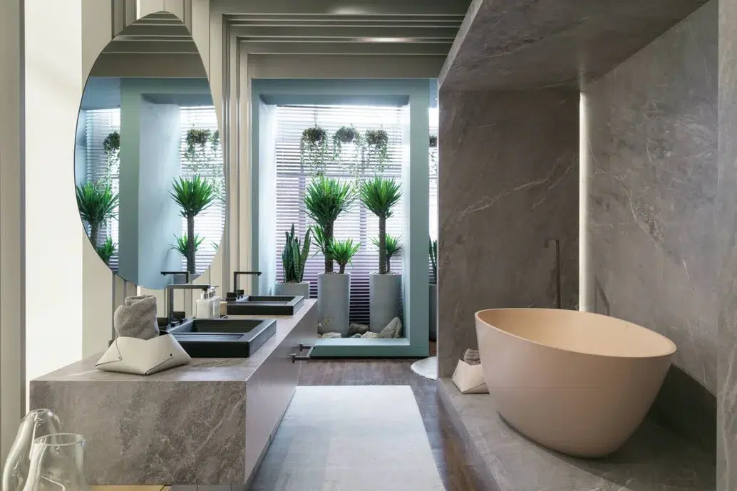 Banheiro cinza em uma suite com decoração de plantas