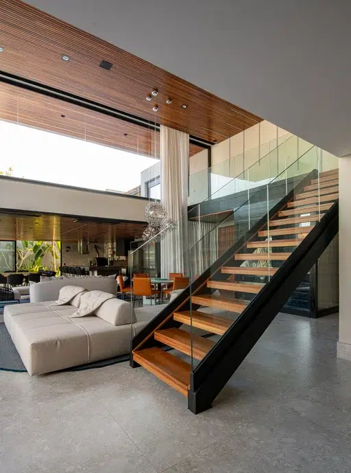 Sala de estar de uma casa com um sofá e uma escada em madeira.