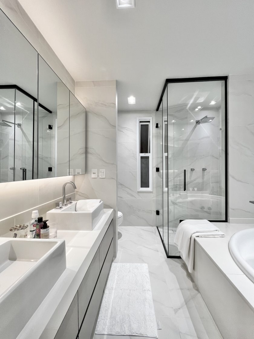 Banheiro de casal com revestimento marmorizado no piso e nas paredes, com ar elegante