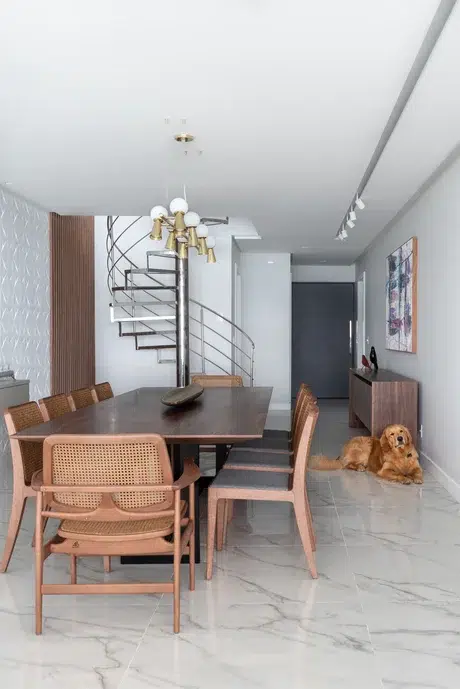Sala de jantar pequena com escada em formato de caracol. 