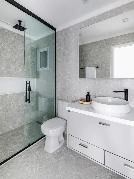 Banheiro moderno de casal com revestimento de  Pietra Lombarda Off no piso e paredes.