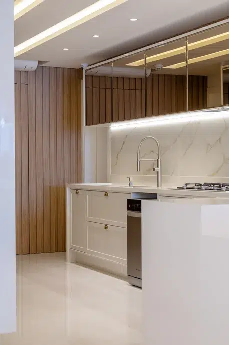 Cozinha branca com um leve ar rústico, revestimento imitando madeira, e porcelanato imitando mármore. 