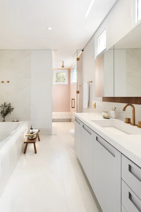 Banheiro de luxo pequeno em cores brancas e detalhes em dourado.