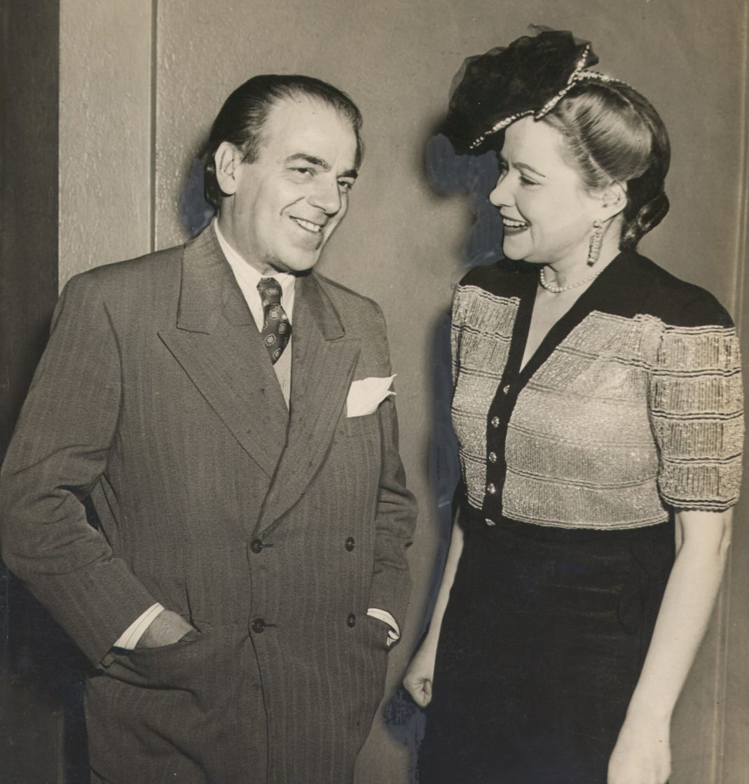 Fotografia de Heitor Villa-Lobos conversando com a soprano brasileira Bidu Sayão, intérprete reconhecida da música lírica no século 20