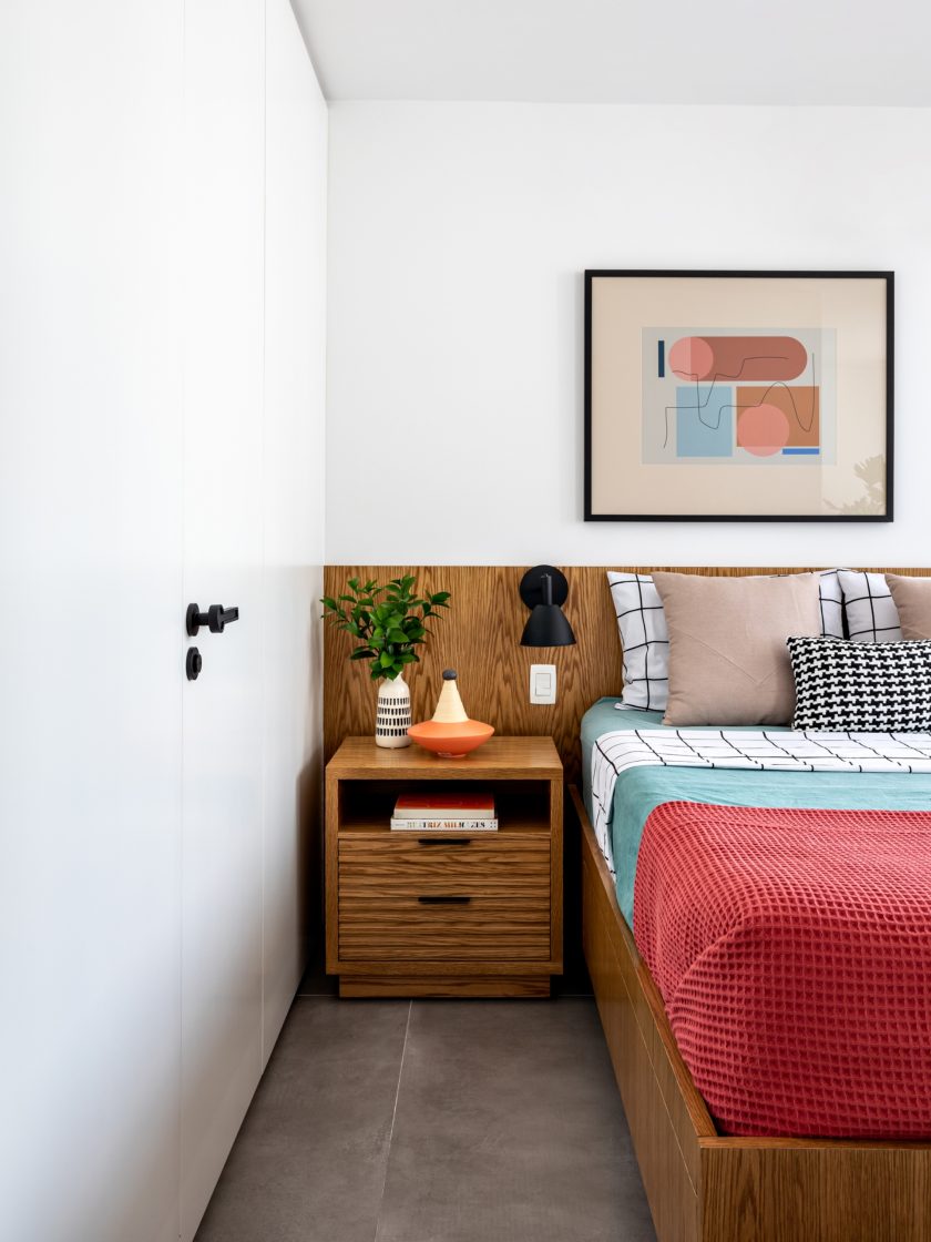quarto decorado com planta, quadro, uma cama e escrivaninha