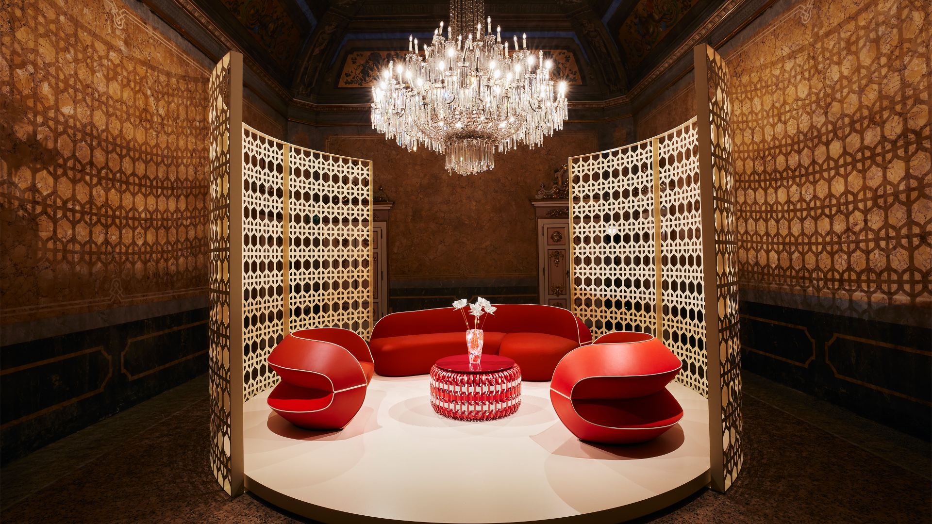Biombo em off white destaca as formas e o tom coral do mobiliário na Louis Vuitton
