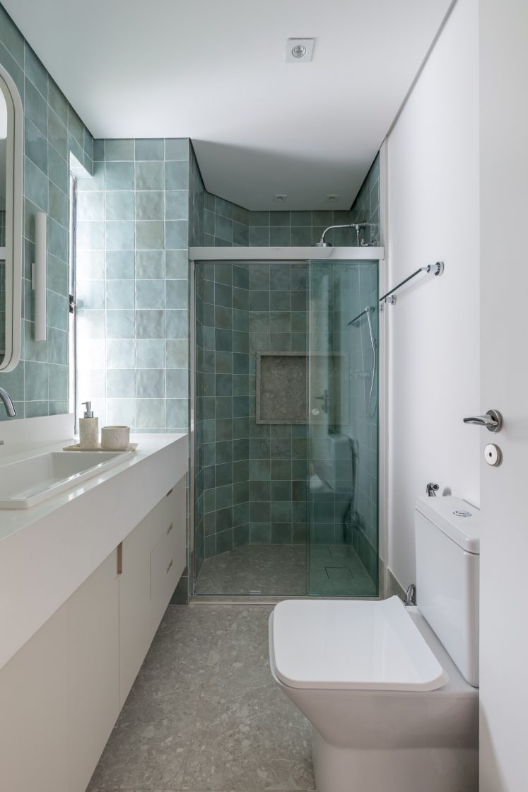 banheiro azul com móvel branco e revestimento no piso em cinza 