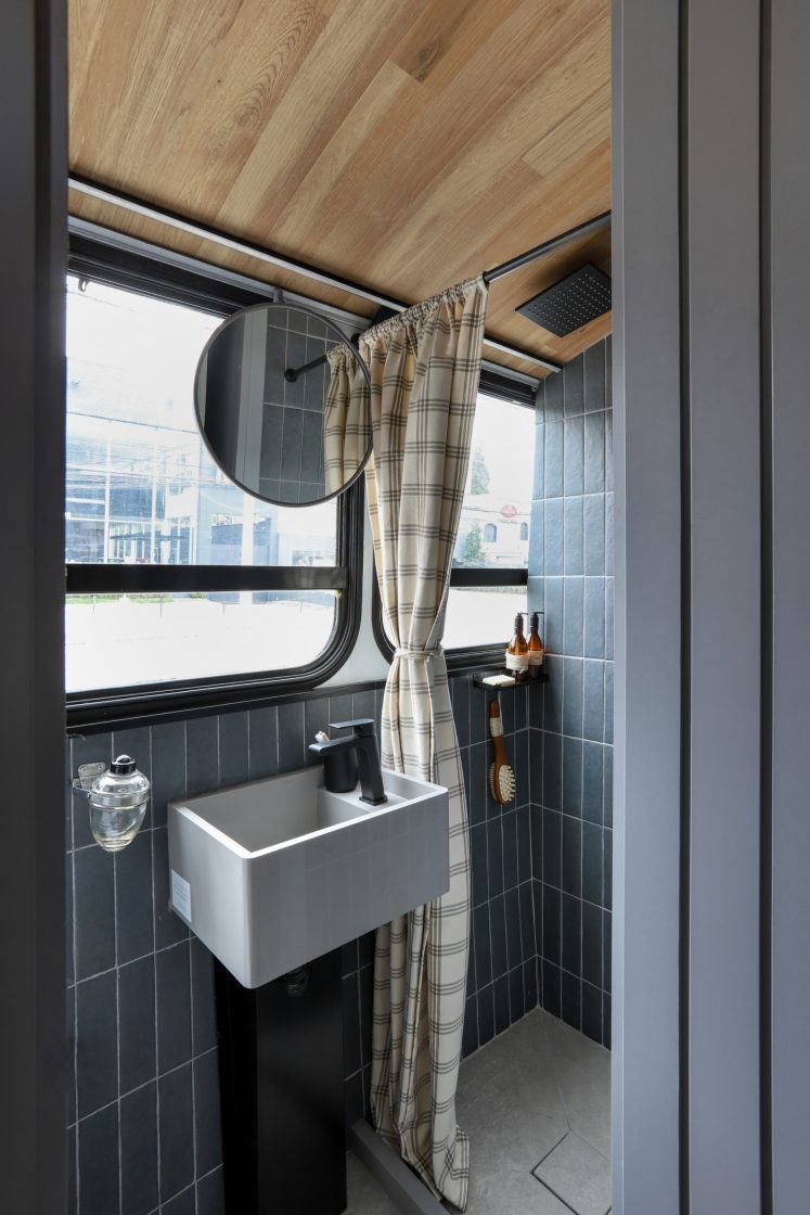 Banheiro com azulejos cinza escuro com design retrô.