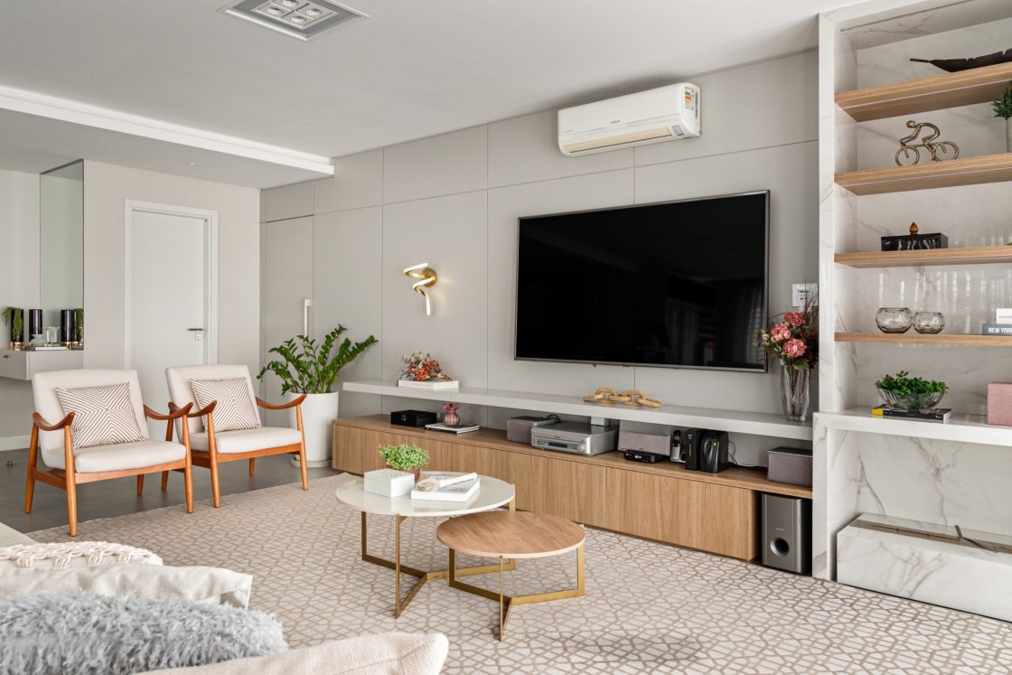 Sala de estar com estante em mármore branco e elementos em madeira