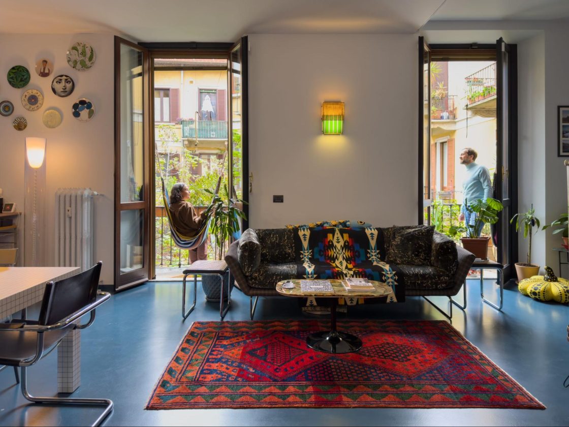 apartamento colorido em Milão, integração de cozinha e quarto, luz natural pelas portas da varanda